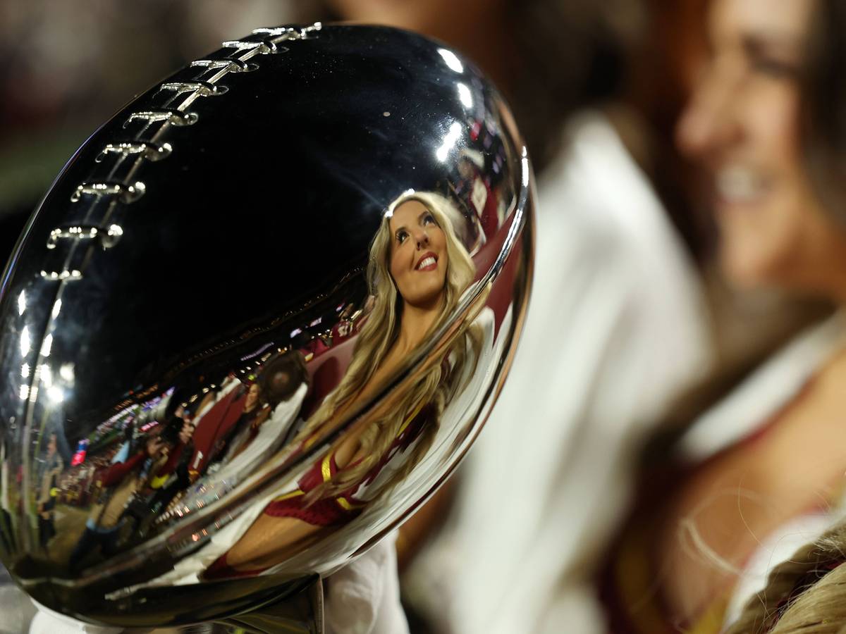Eine Cheerleaderin spiegelt sich in der Super-Bowl-Trophäe.