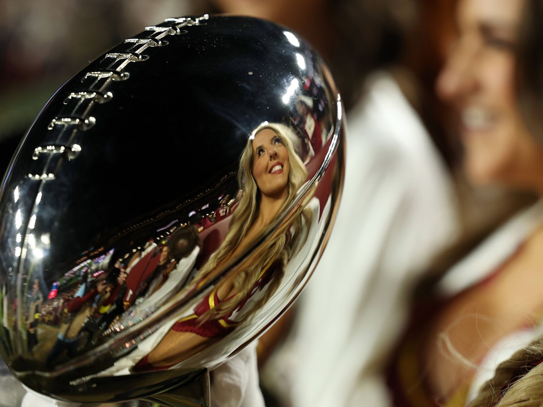 Eine Cheerleaderin spiegelt sich in der Super-Bowl-Trophäe.
