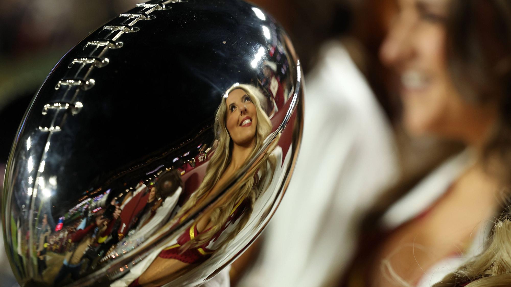 Eine Cheerleaderin spiegelt sich in der Super-Bowl-Trophäe.