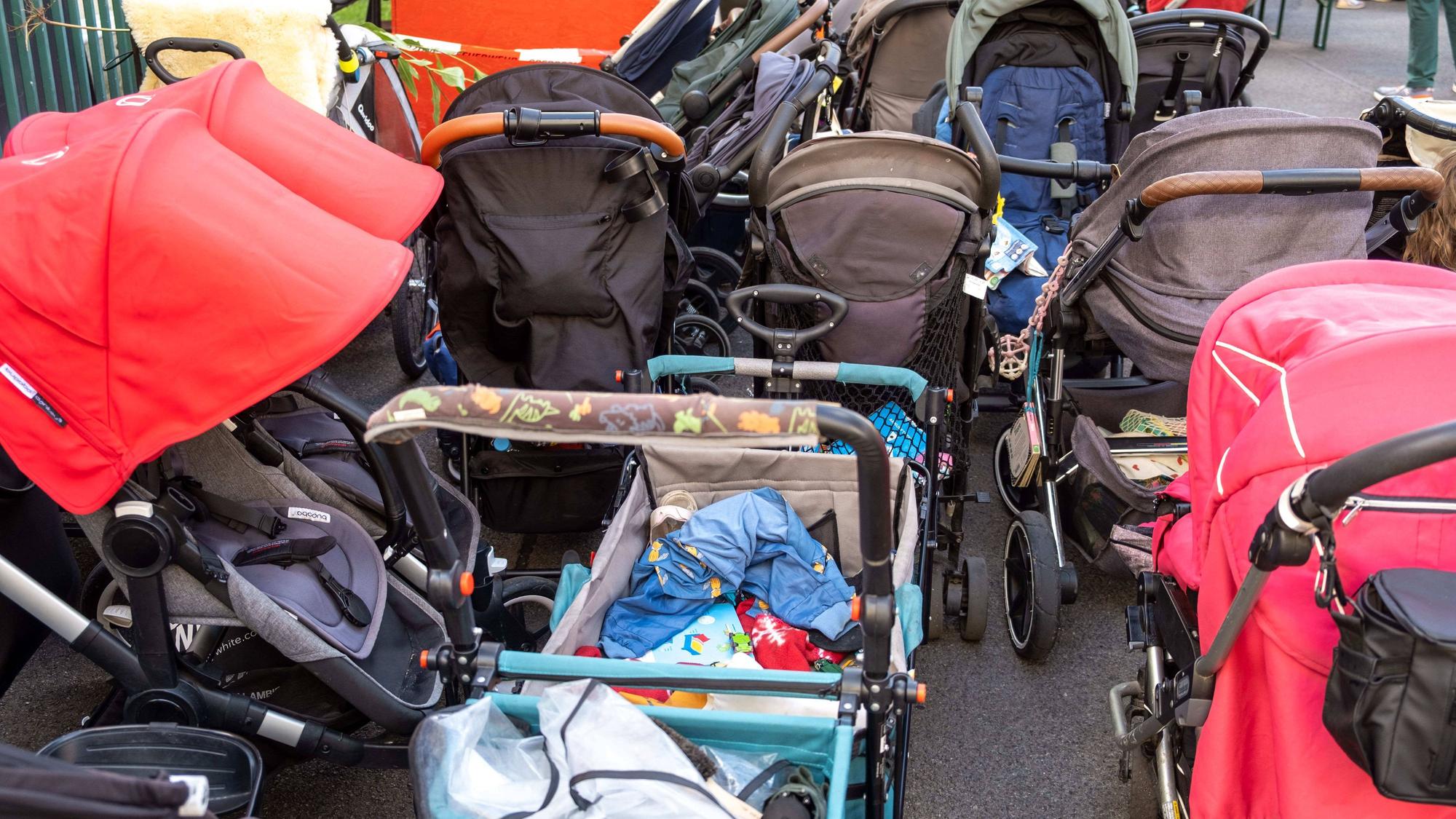 Viele Kinderwagen stehen nebeneinander