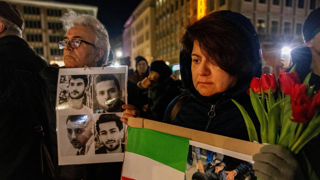 Trauernde Menschen mit Fotos Verstorbener und einer Iran-Flagge vor dem Dom.