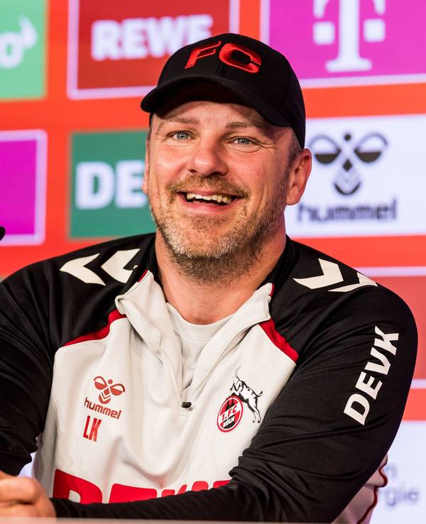 Trainer Lukas Kwasnok lacht auf der Pressekonferenz des 1. FC Köln