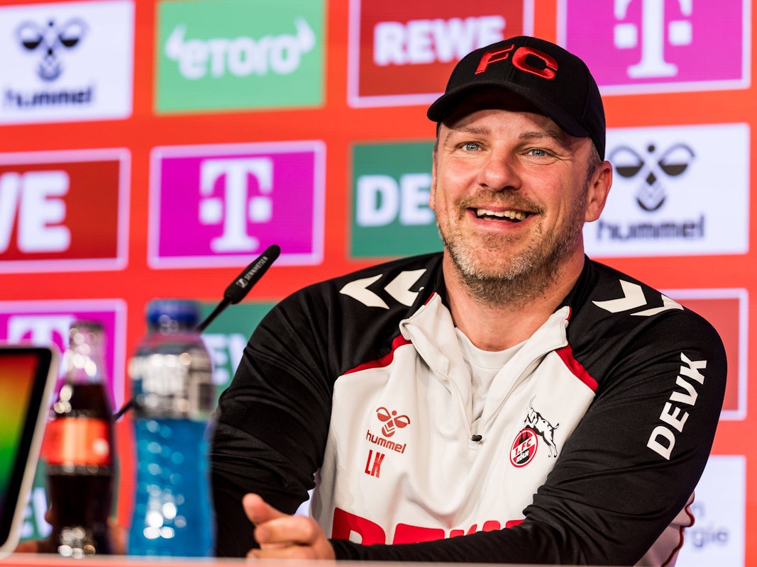 Trainer Lukas Kwasnok lacht auf der Pressekonferenz des 1. FC Köln
