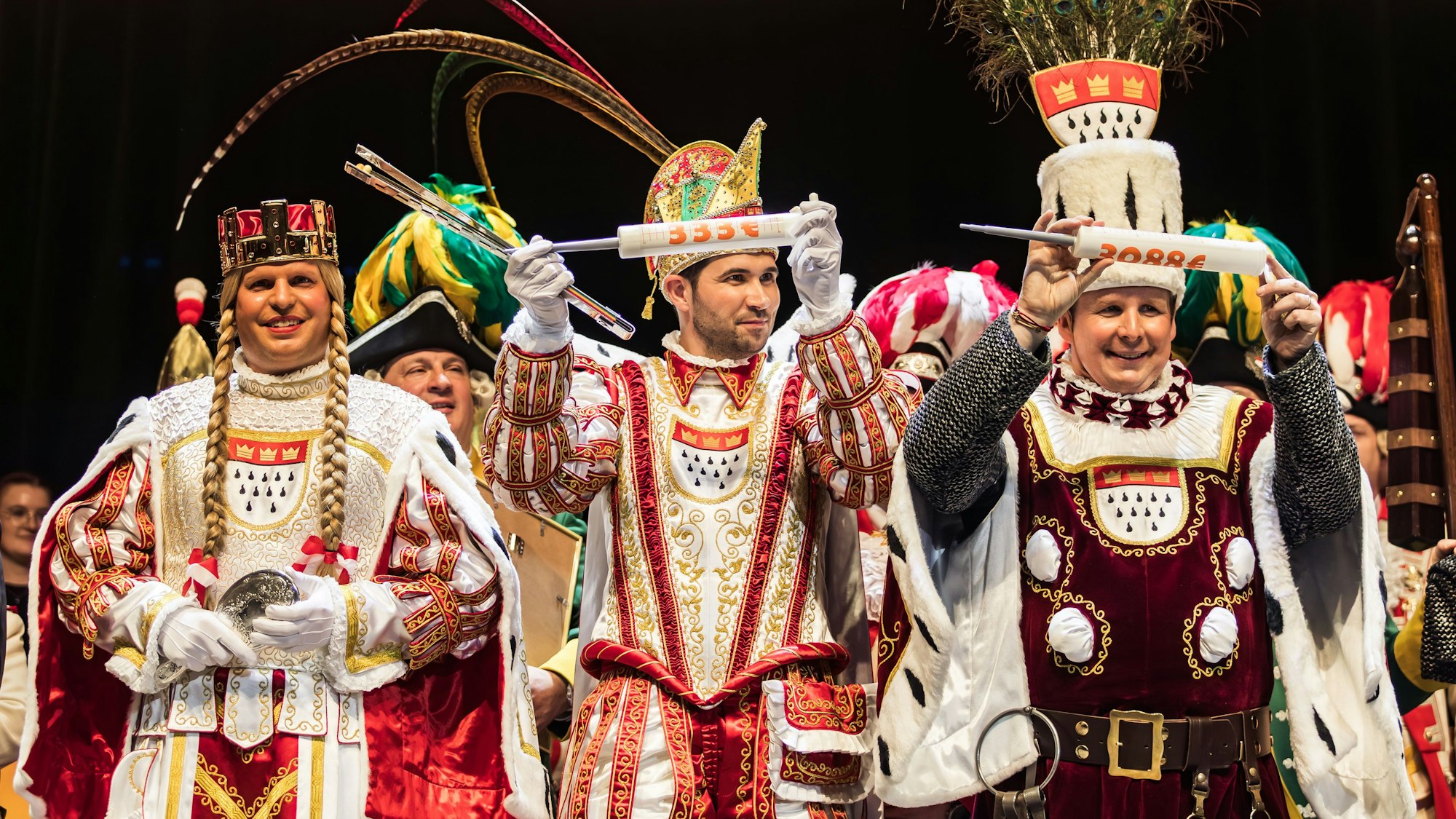 Das Dreigestirn hält die Spenden-Spritzen hoch.