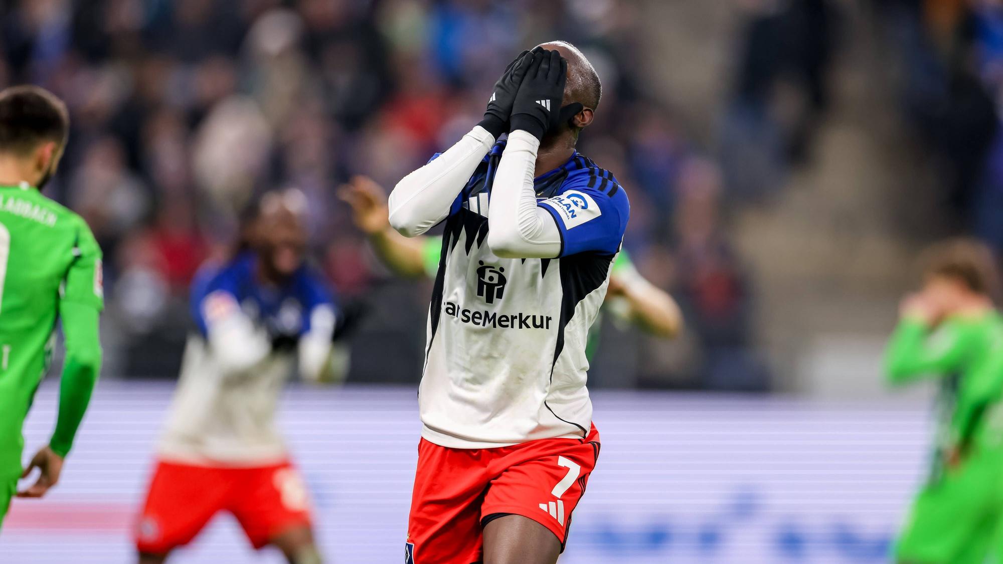 Jean-Luc Dompé hadert bei einem HSV-Spiel und hält sich die behandschuhten Hände vors Gesicht.