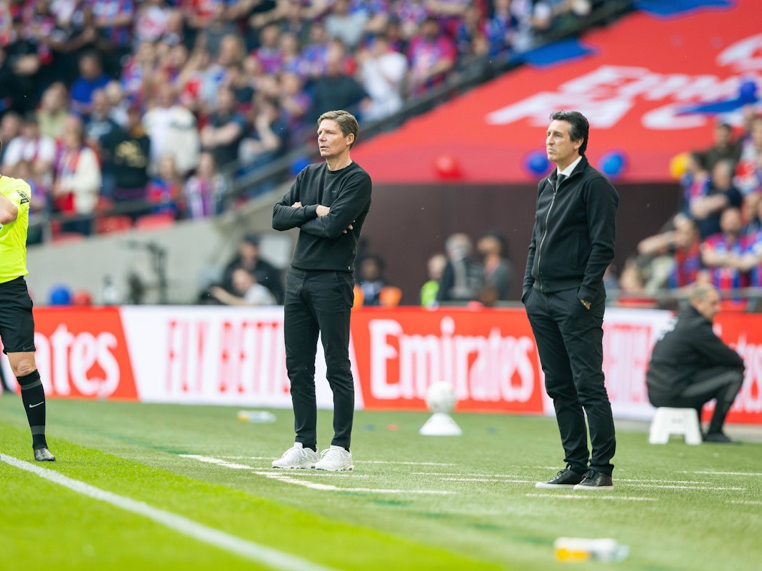 Oliver Glasner (M.) und Unai Emery (r.) stehen an der Seitenlinie bei einem Spiel.