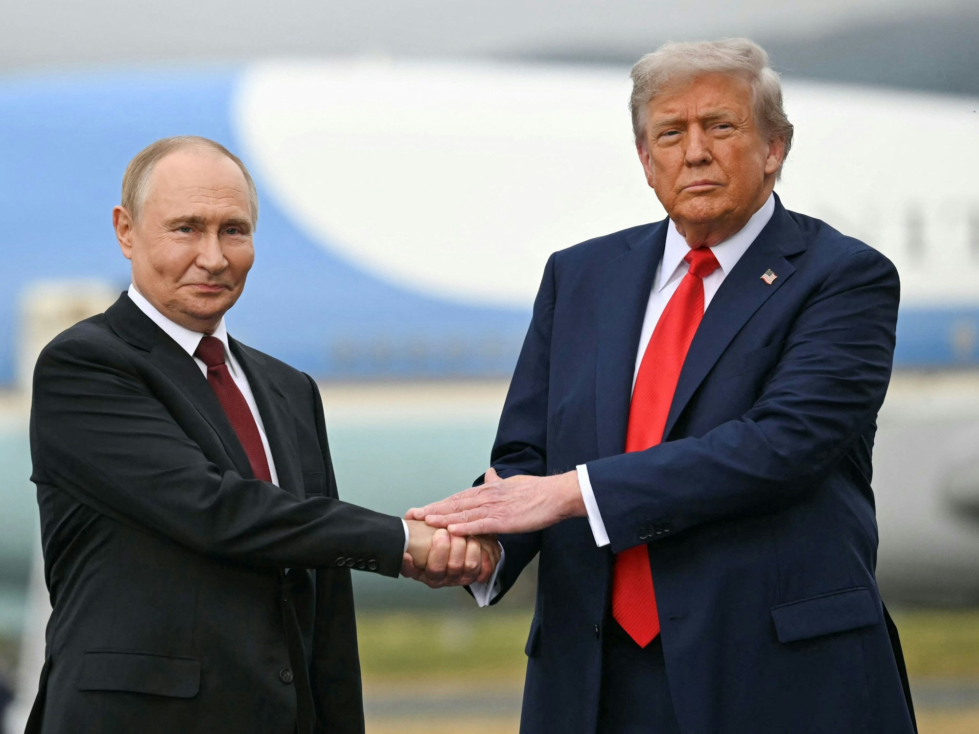 Donald Trump (r.) und Wladimir Putin geben sich die Hand.