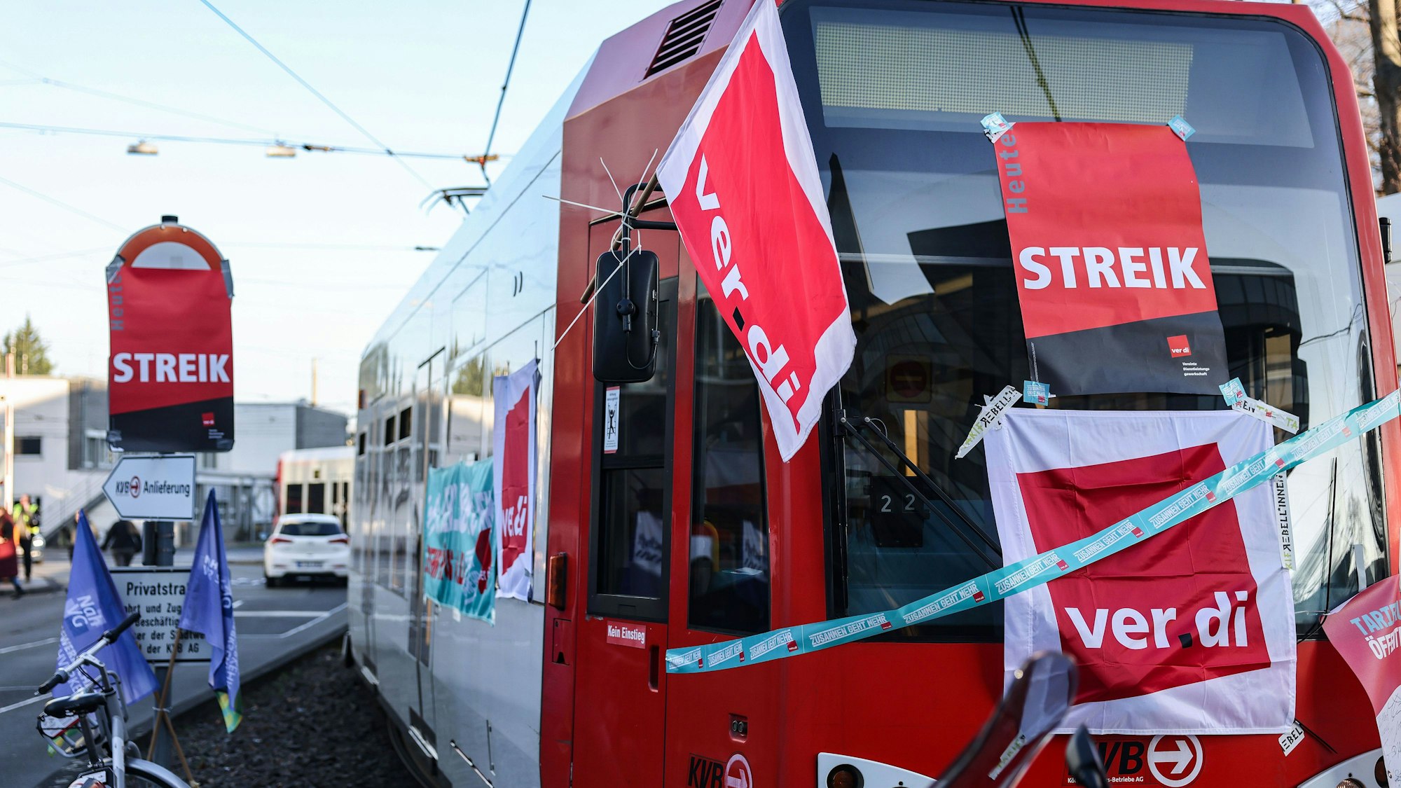 Eine mit Streik-Plakaten beklebte Straßenbahn der Kölner Verkehrs-Betriebe (KVB) steht vor dem Bahndepot.