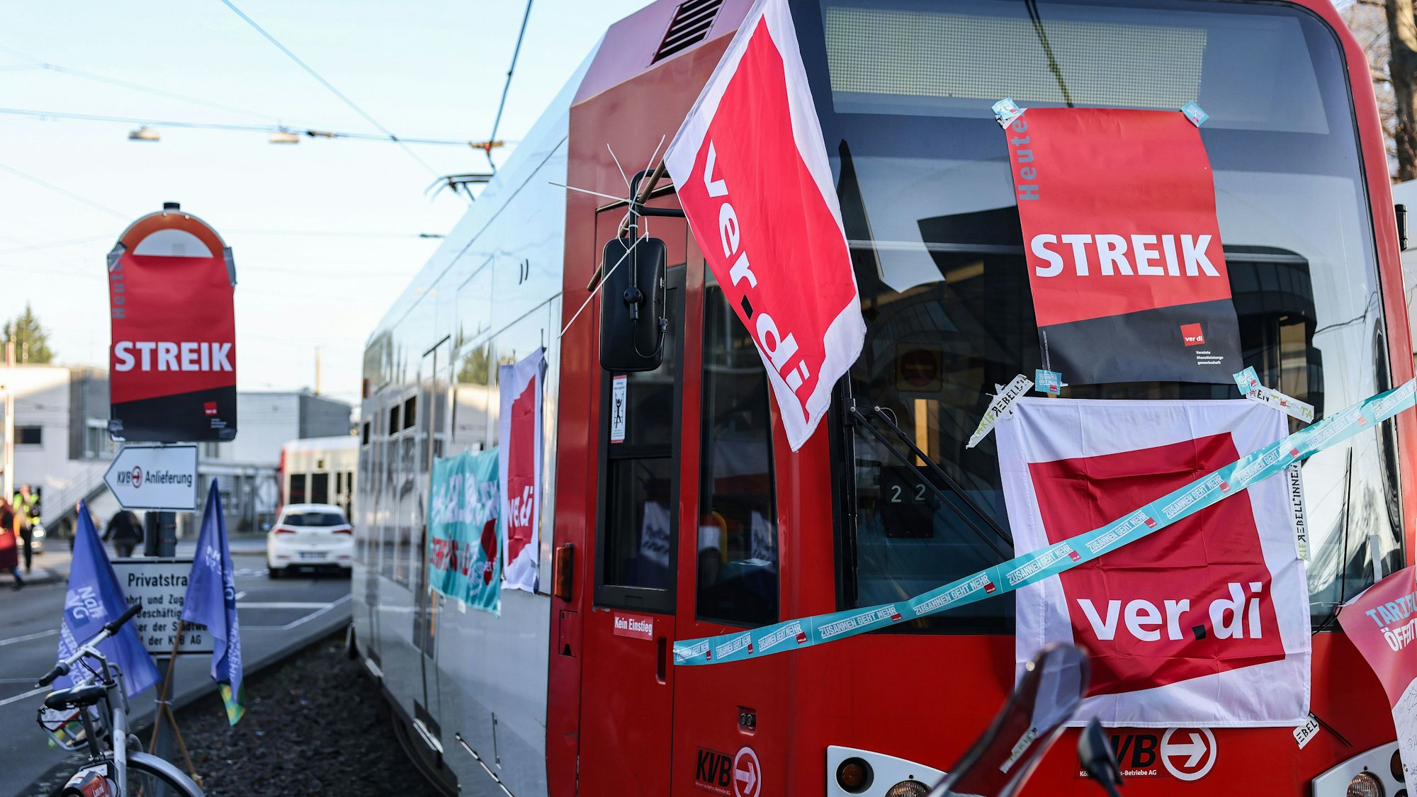 Eine mit Streik-Plakaten beklebte Straßenbahn der Kölner Verkehrs-Betriebe (KVB) steht vor dem Bahndepot.