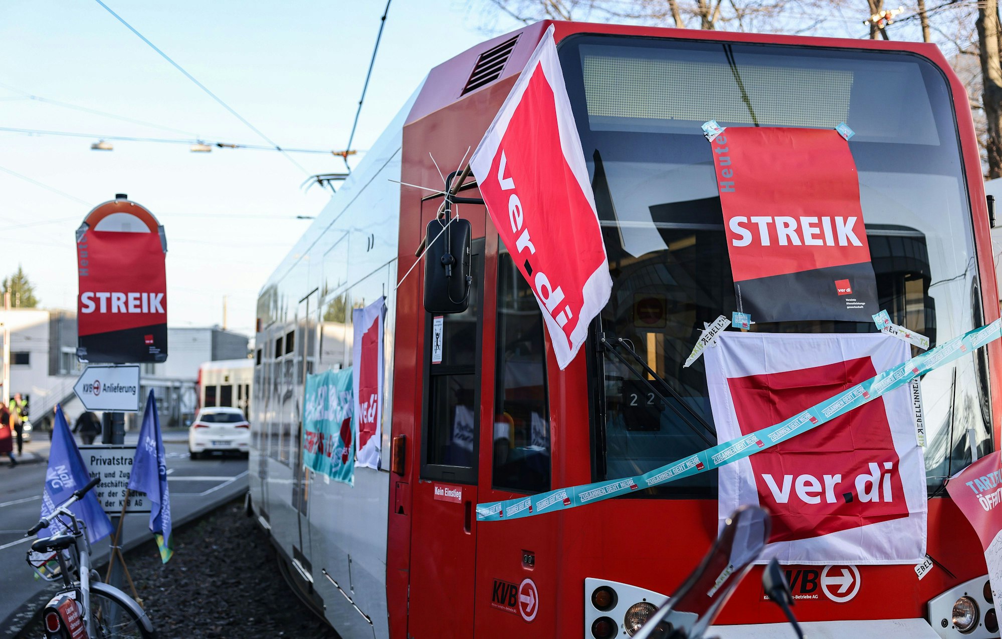 Eine mit Streik-Plakaten beklebte Straßenbahn der Kölner Verkehrs-Betriebe (KVB) steht vor dem Bahndepot (Archivbild).