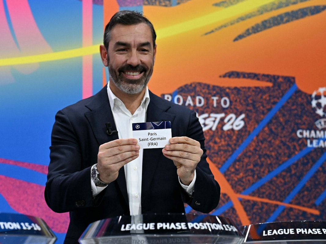 Robert Pirès hält ein Los mit dem Vereinsnamen von Paris Saint-Germain in der Hand.