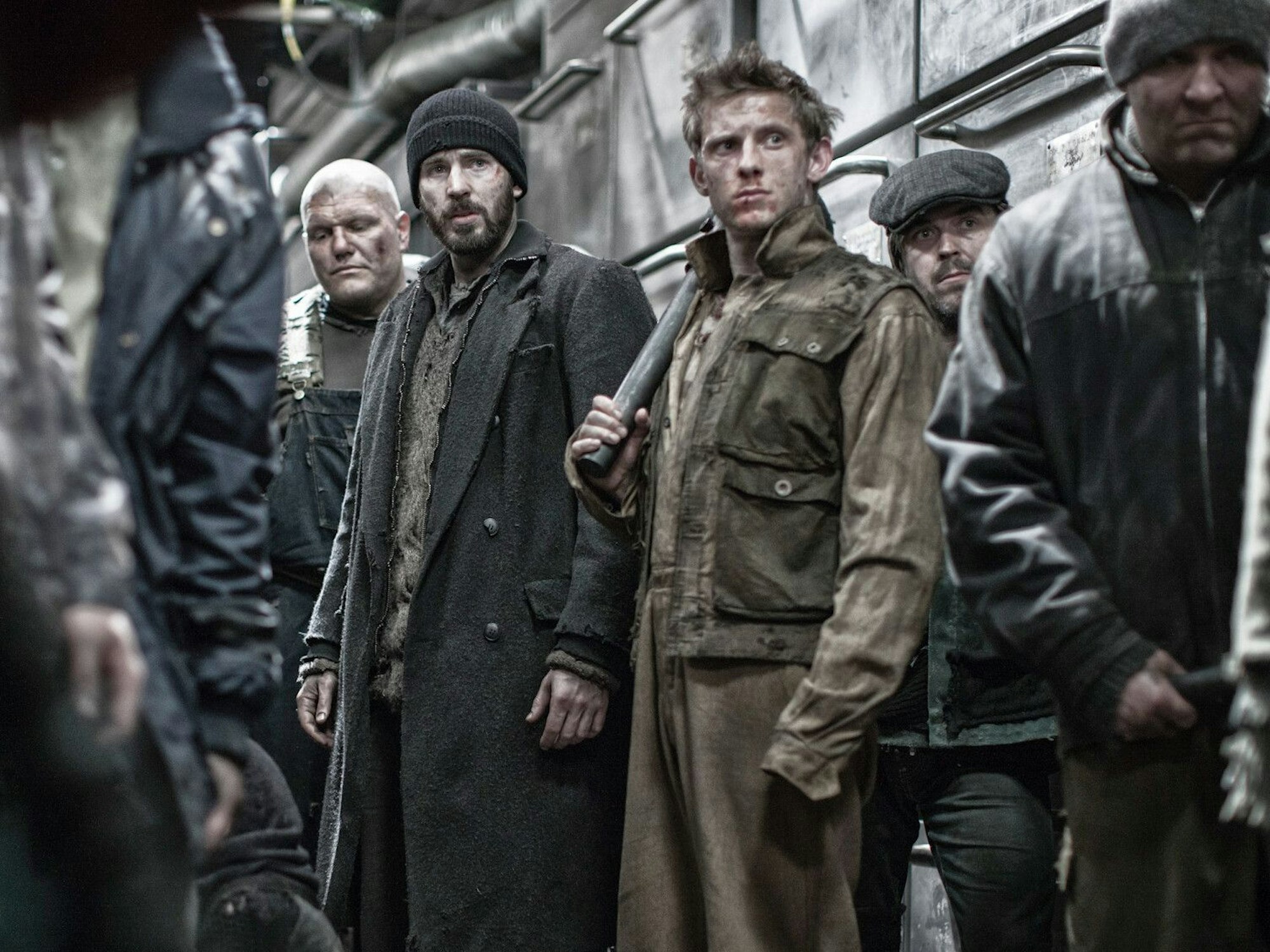 Männer mit schmutzigen Gesichtern und dreckigen Kleidern stehen vor einem Zug.