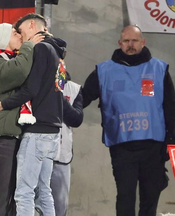 Zwei Männer küssen sich nach einem Heiratsantrag im FC-Stadion.