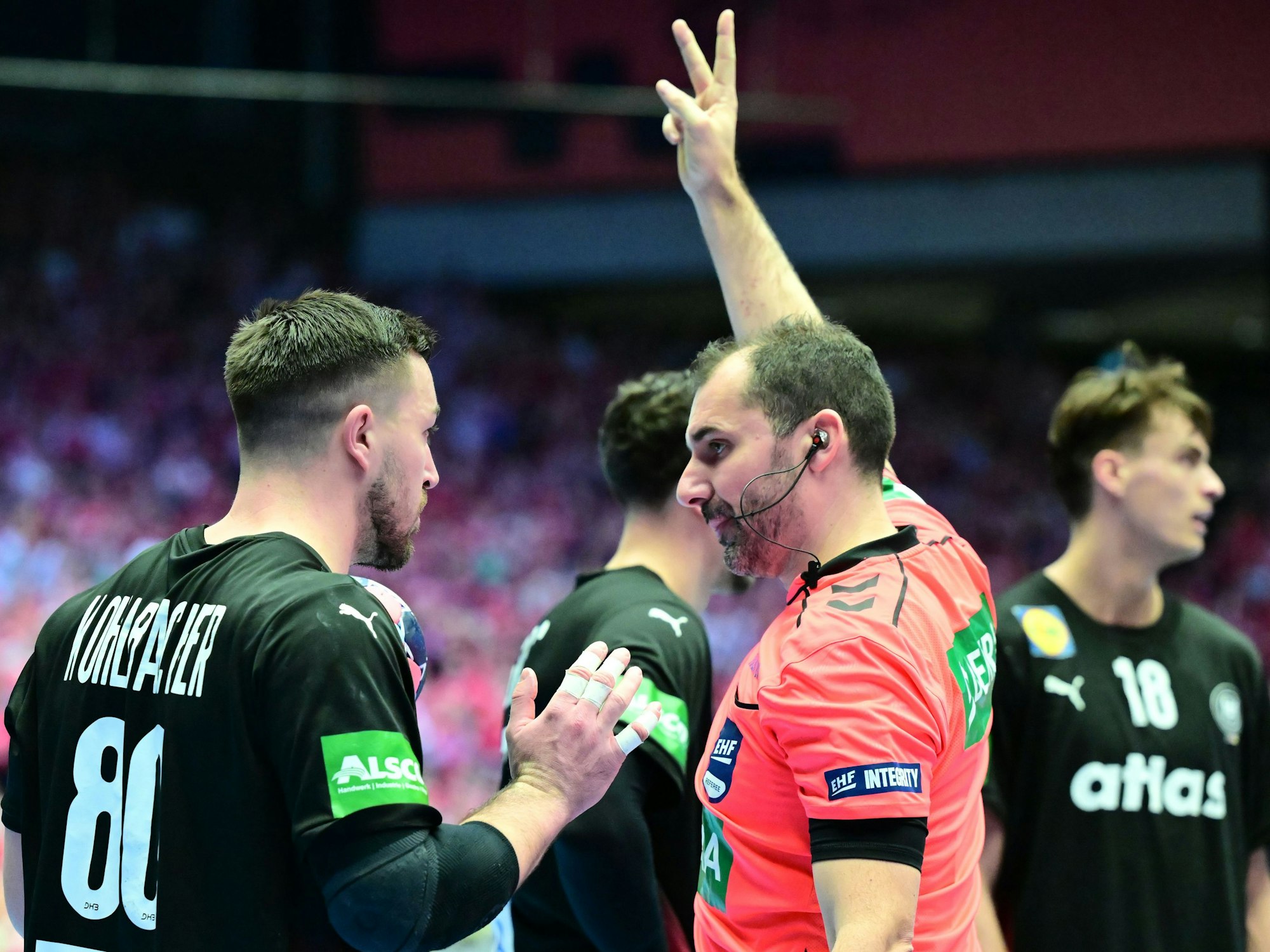 Jannik Kohlbacher (l, Deutschland) bekommt von Schiedsrichter Milos Raznatovic (r, Montenegro) eine Zeitstrafe angezeigt.