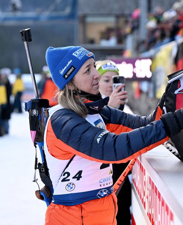 Franziska Preuß nimmt nach einem Biathlon-Rennen eine deutsche Fahne in die Hand.
