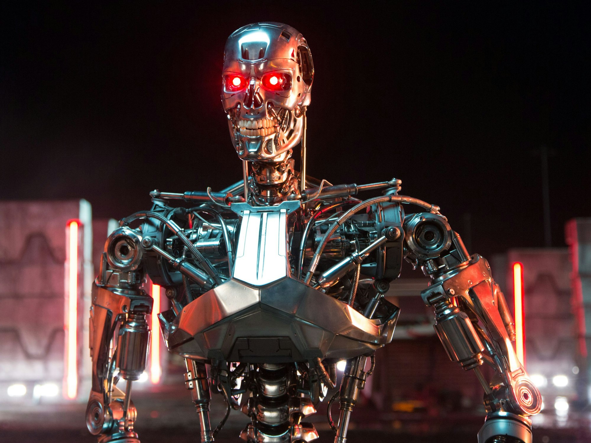 Eine Figur aus Chrom, die an ein Skelett erinnert und deren Augen rot leuchten, fletscht die Zähne.