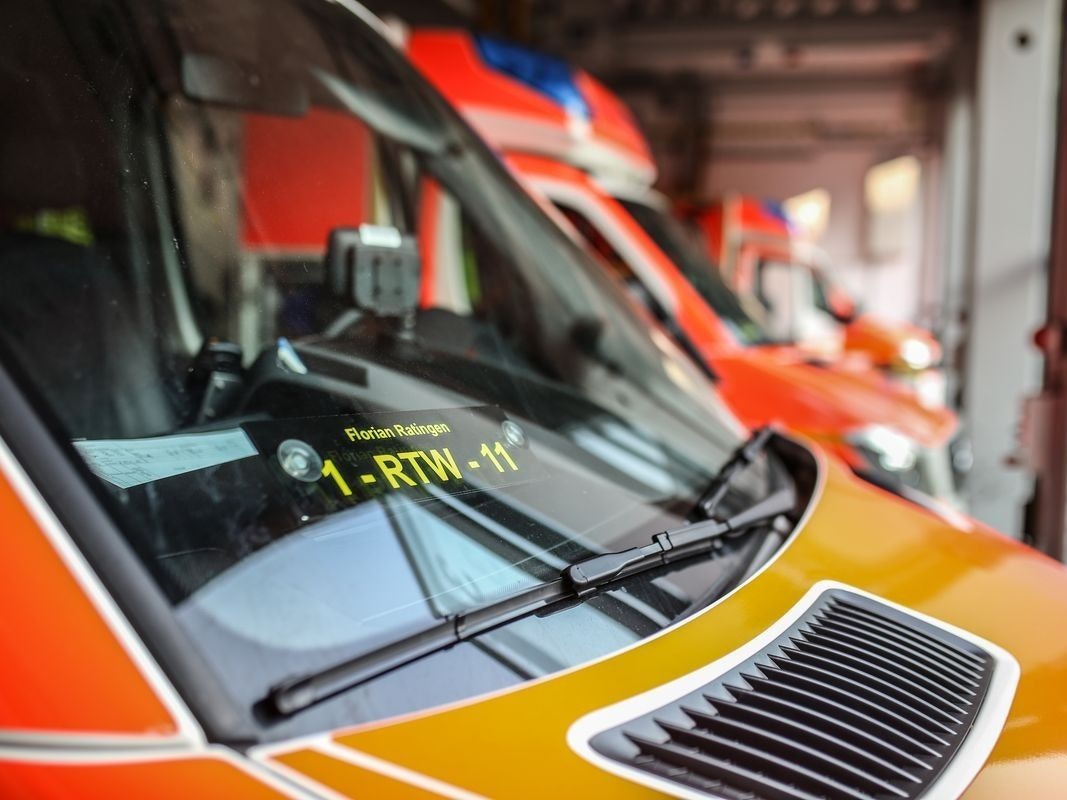 Ein Linienbus steht an einer Kreuzung, Feuerwehr im Hintergrund.