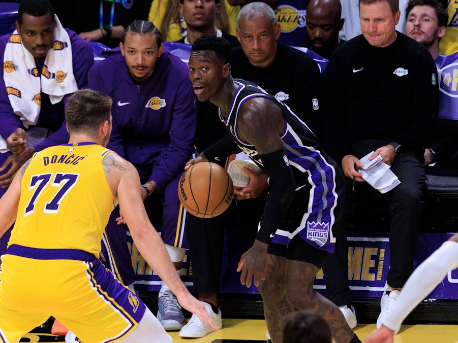 Dennis Schröder (r.) im Trikot der Sacramento Kings bereitet sich auf einen Pass vor, während Luka Doncic von den Los Angeles Lakers verteidigt.