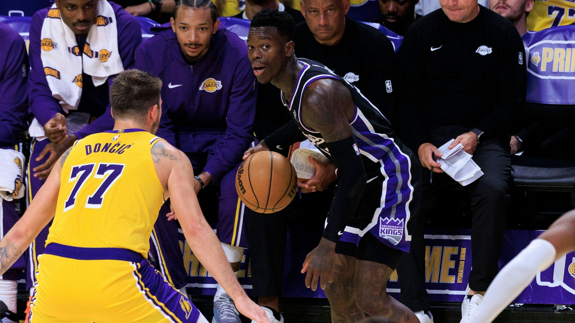 Dennis Schröder (r.) im Trikot der Sacramento Kings bereitet sich auf einen Pass vor, während Luka Doncic von den Los Angeles Lakers verteidigt.