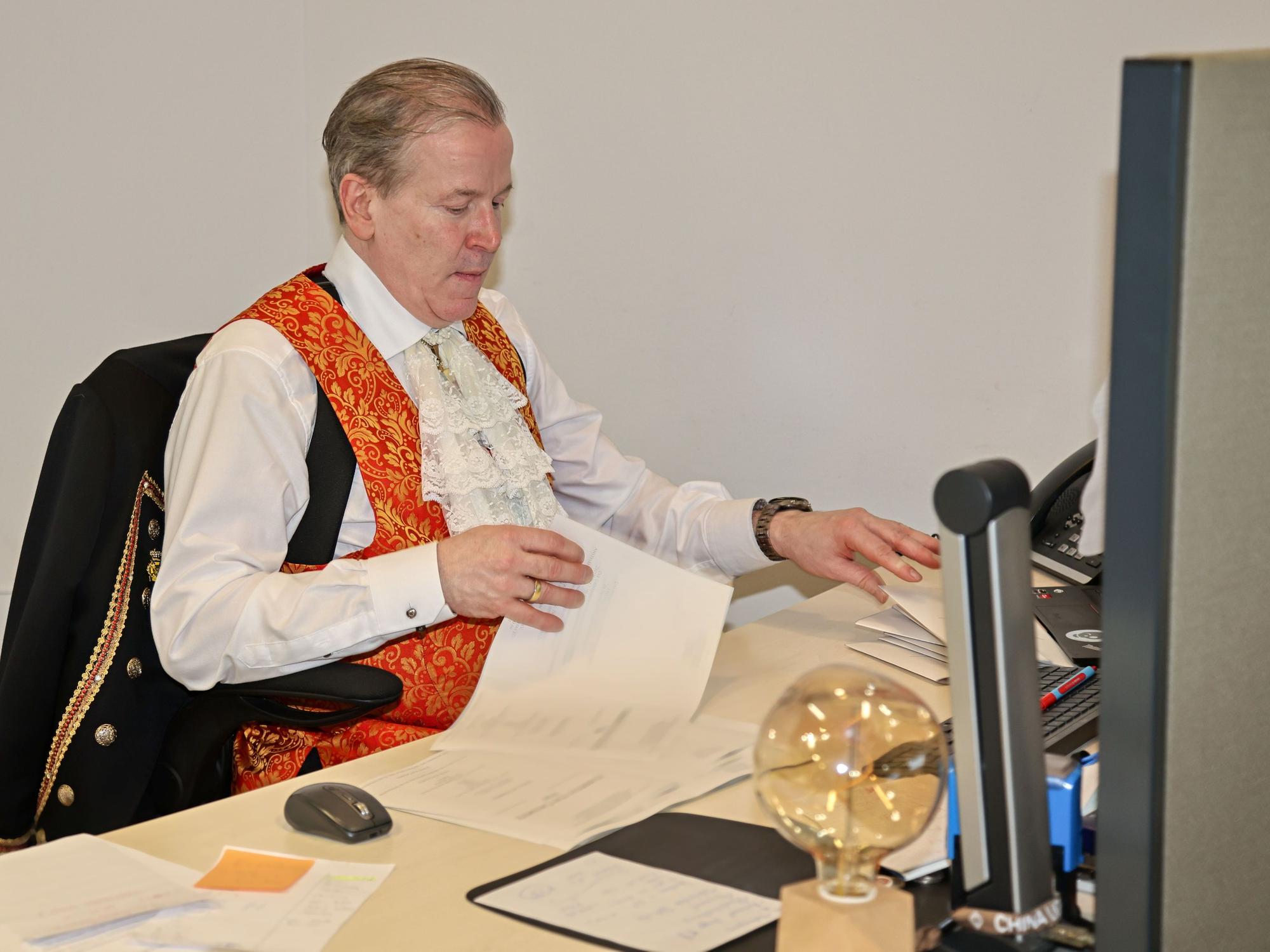 Christoph Kuckelkorn sitzt am Schreibtisch.
