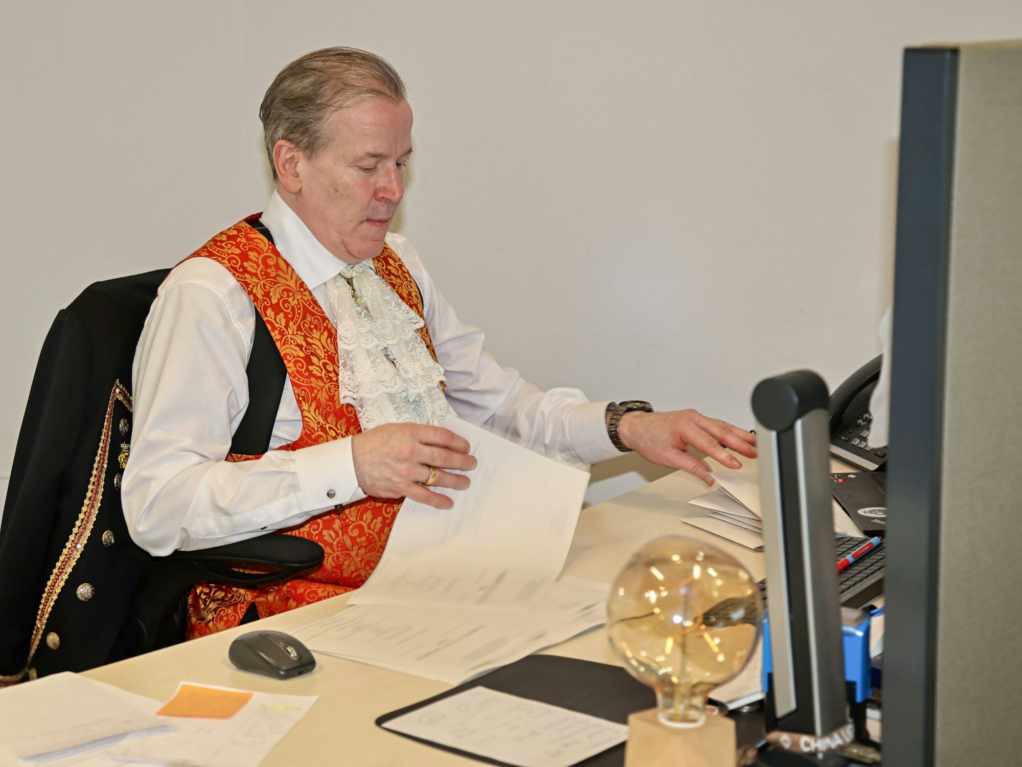 Christoph Kuckelkorn sitzt am Schreibtisch.