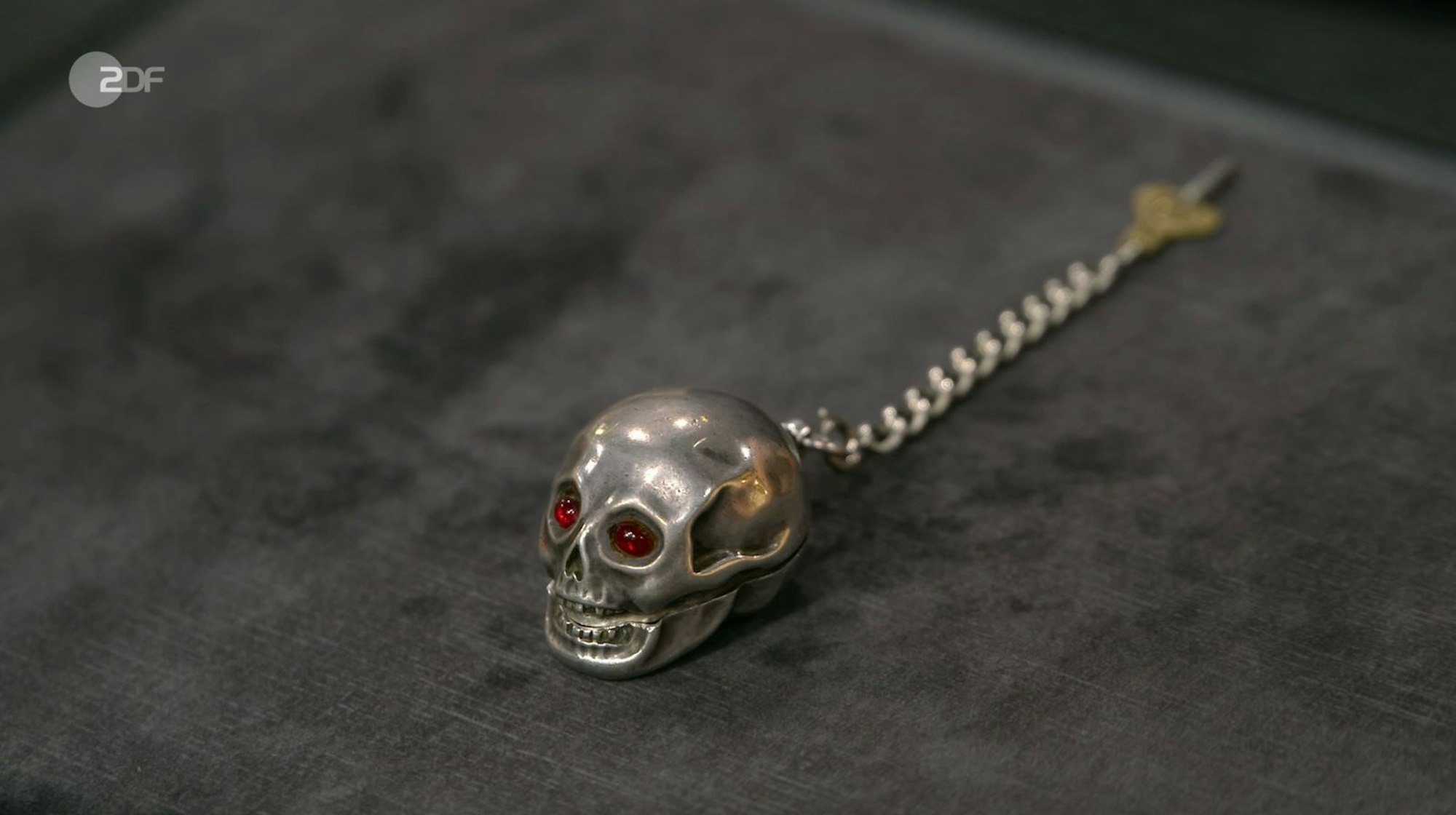 Sven Deutschmanek benannte die Totenkopf-Spindeluhr aus Silber als „Memento mori“ und datierte sie zwischen 1810 und 1830. Gewünscht wurden 1.000 Euro, der Experte schätzte 1.100 bis 1.400 Euro, „denn diese Taschenuhren mit Totenkopf sind bei Sammlern sehr, sehr beliebt“. Ferdinand Resul Adanir zahlte 1.050 Euro. (Bild: ZDF)