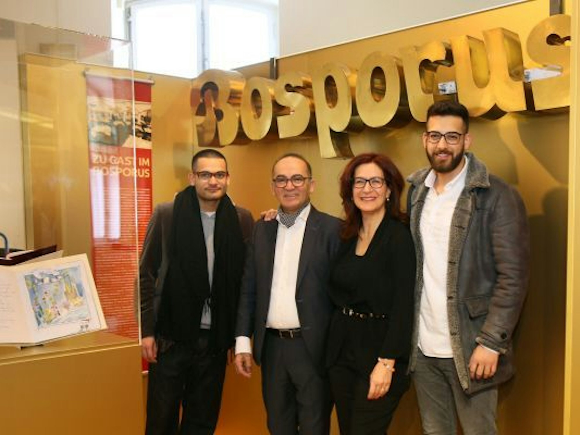 Personen stehen an einer Museumsvitrine.