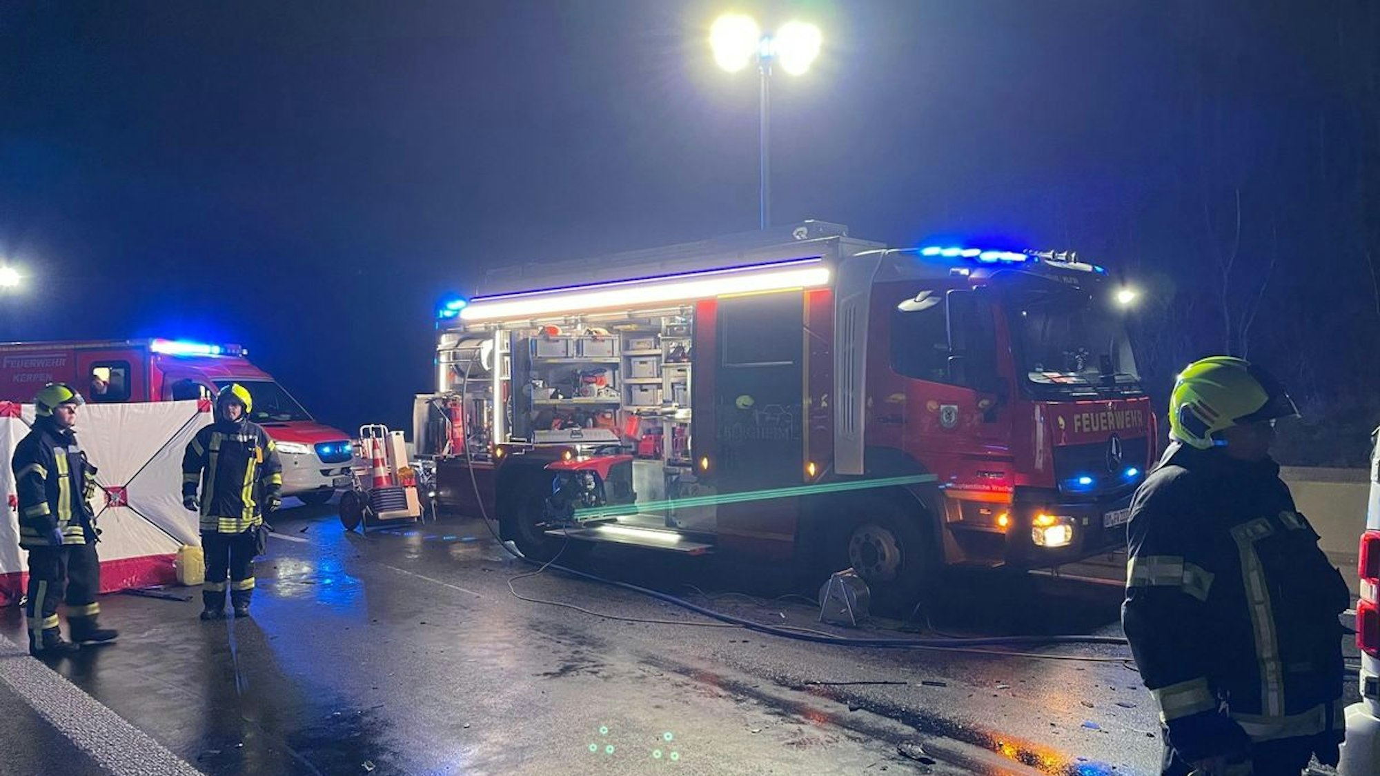 Die Unfallstelle auf der A61 bei Bergheim mit mehreren Rettungsfahrzeugen.