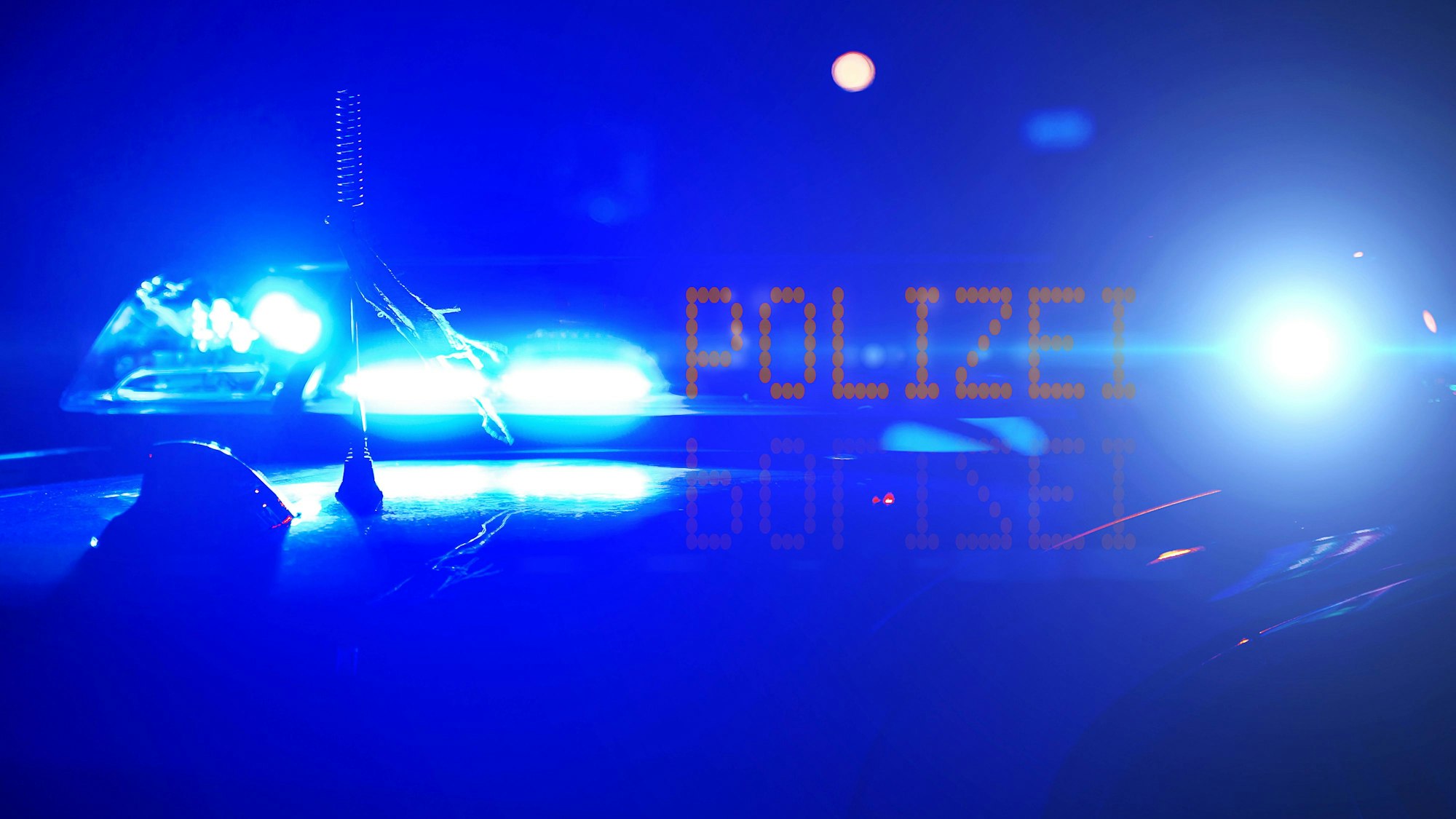 Polizeiwagen mit Blaulicht und POLIZEI-Anzeige