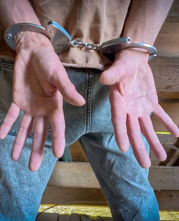 Menschliche Hände mit Handschellen, Symbolbild
