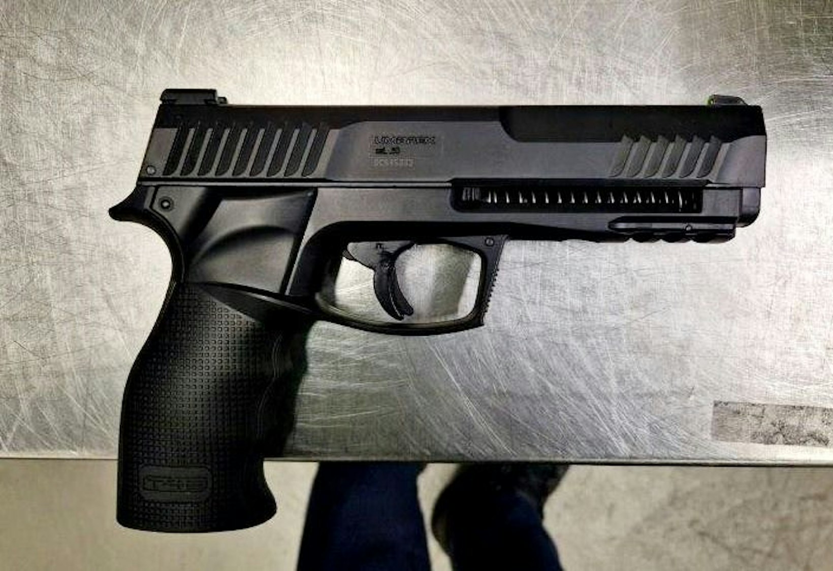 Sichergestellte Druckluftpistole mit Zubehör liegt auf einem Tisch.