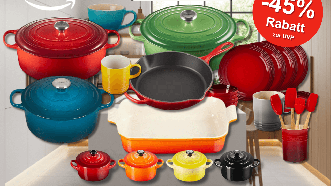 Eine edle Küche mit einem Silvester Feuerwerk vor dem Fenster, davor Le Creuset Küchenprodukte in verschiedenen Farben und Modellen, darunter Bräter, Pfannen, Tassen und Auflaufformen – in Schwarz, Rot, Blau, Grün und Orange.
