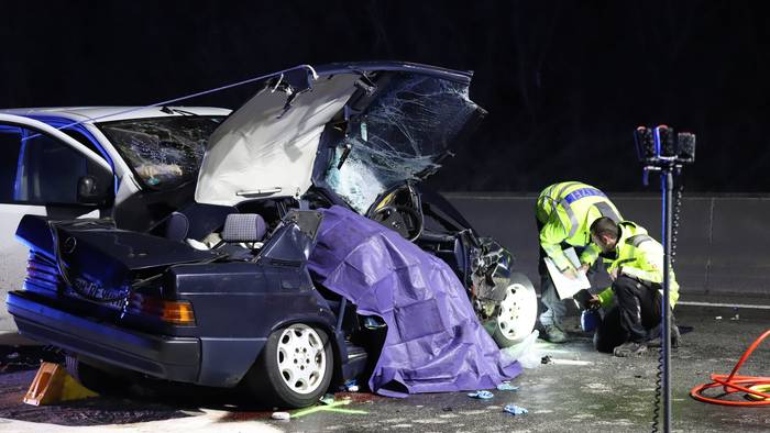 Einsatzkräfte der Polizei untersuchen ein Unfallfahrzeug. +