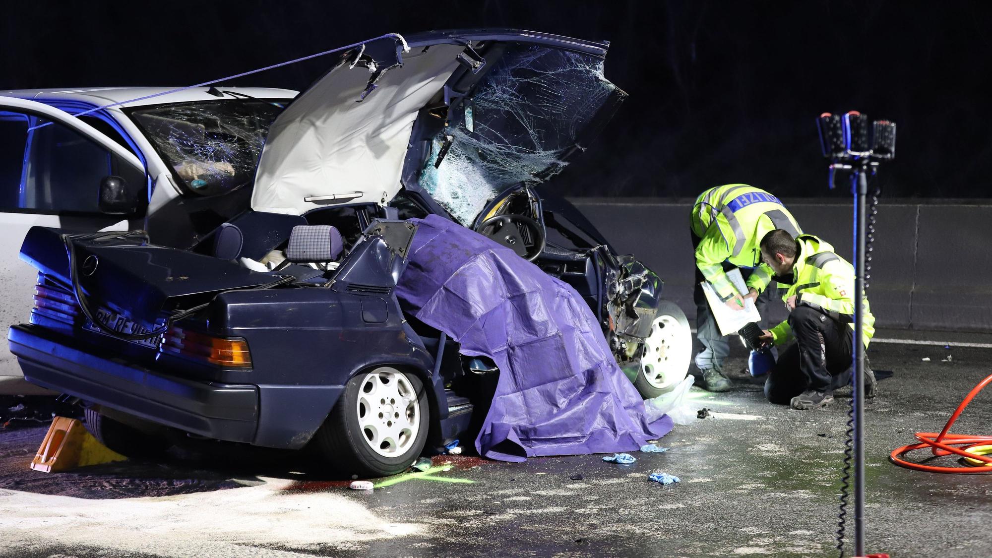Einsatzkräfte der Polizei untersuchen ein Unfallfahrzeug. +