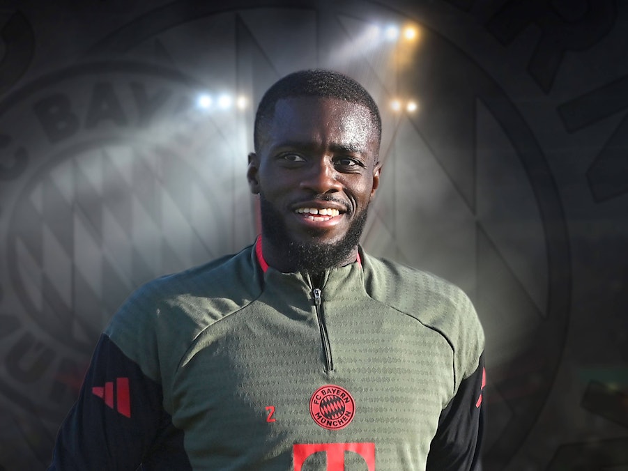 Dayot Upamecano vor dem Bayern-Logo in Trainingsklamotten des Rekordmeisters.