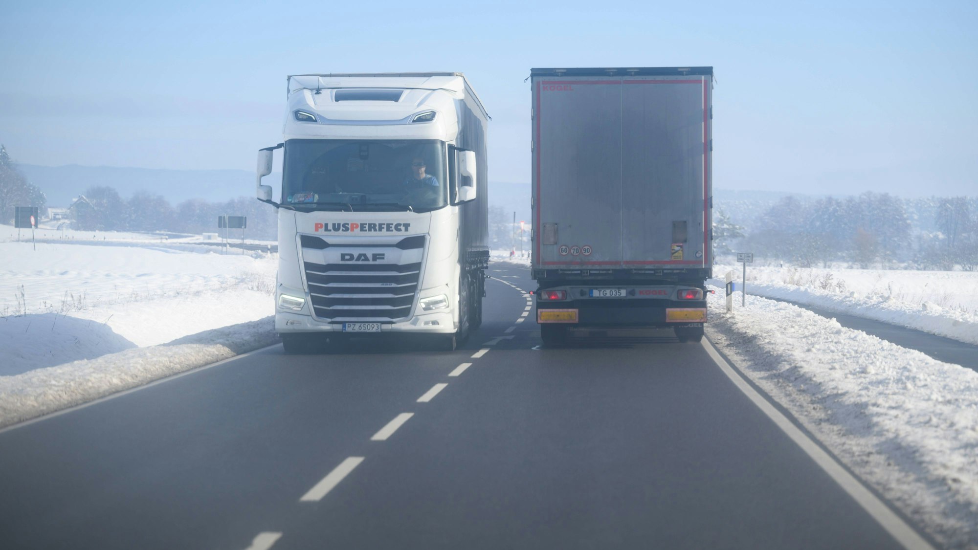 Zwei Lastwagen auf verschneiter Straße