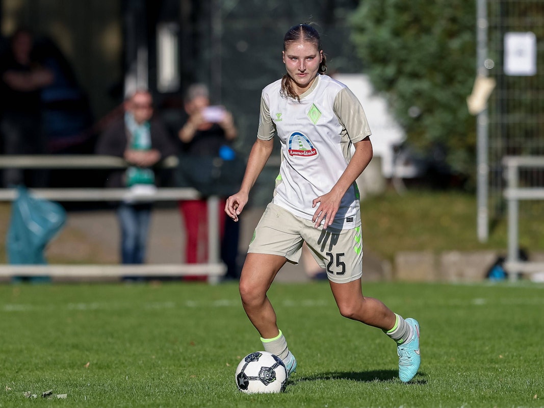 Lina Szaraz, im Trikot von Werder Bremen, läuft mit dem Ball am Fuß über das Spielfeld.