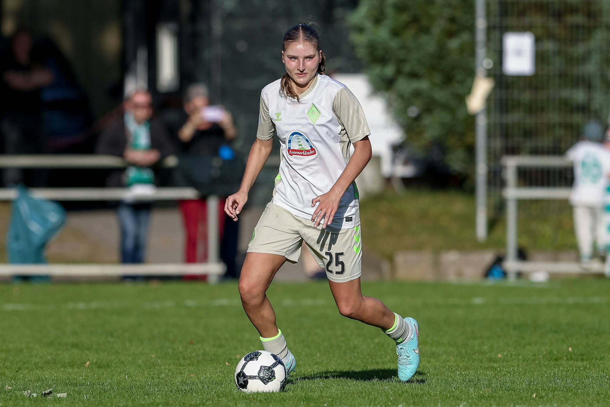 Lina Szaraz, im Trikot von Werder Bremen, läuft mit dem Ball am Fuß über das Spielfeld.