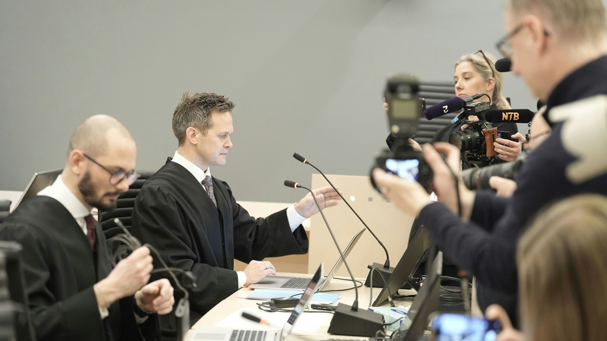 Staatsanwalt Sturla Henriksbø und Ermittlungsleiter Andreas Kruszewski werden von Presseleuten fotografiert und gefilmt.