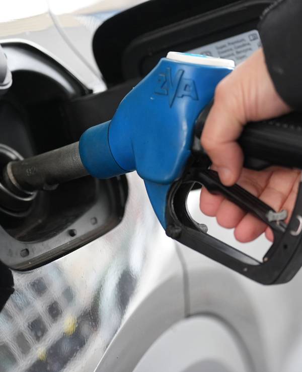 Ein Mann tankt an einer Tankstelle ein Auto.