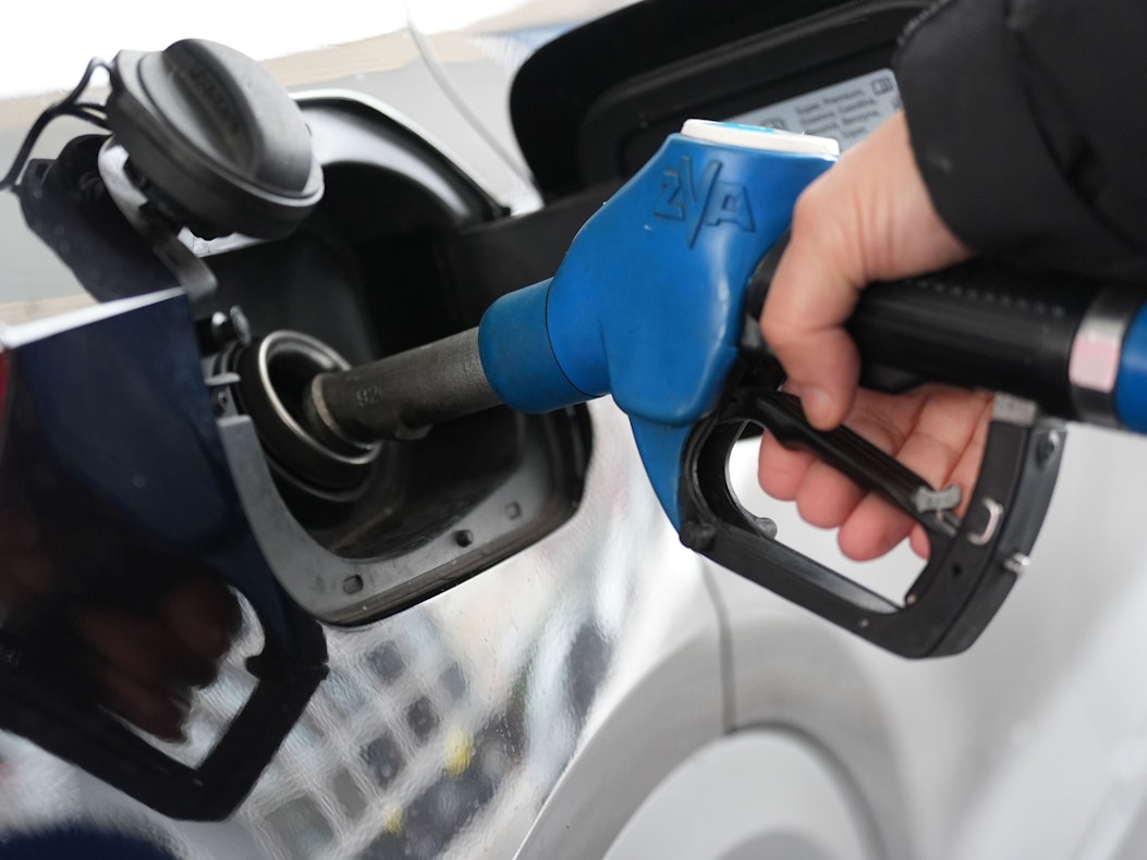 Ein Mann tankt an einer Tankstelle ein Auto.