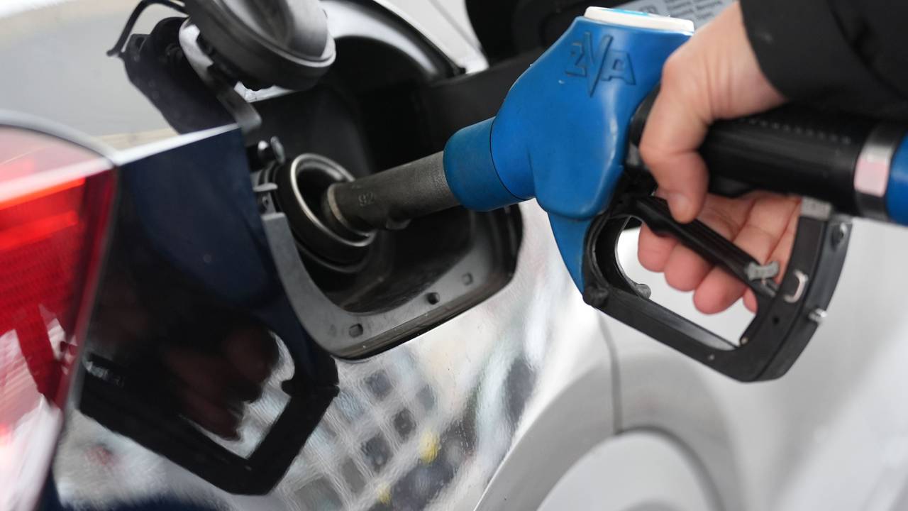 Ein Mann tankt an einer Tankstelle ein Auto.