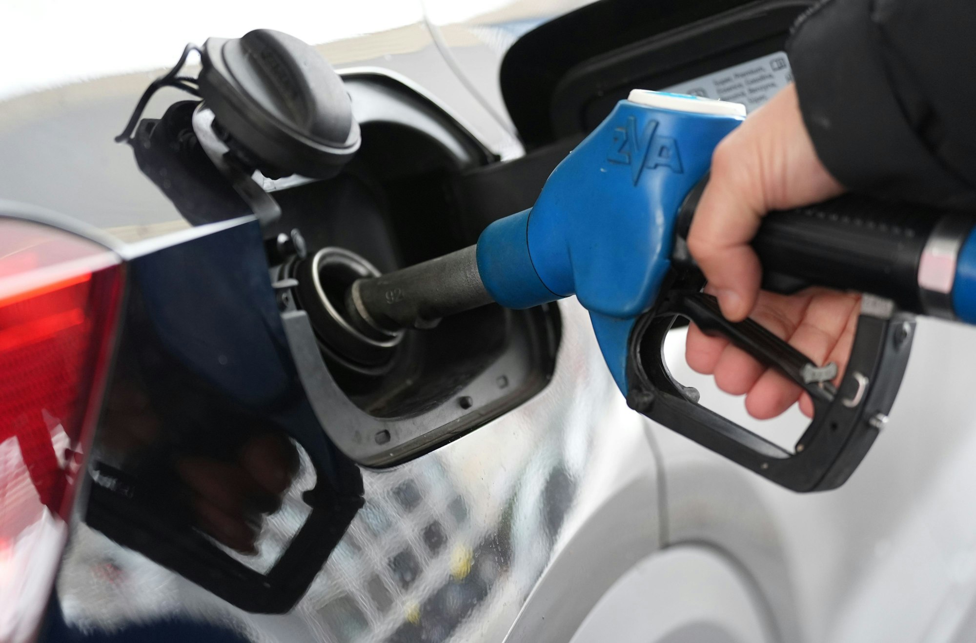 Ein Mann tankt an einer Tankstelle ein Auto.