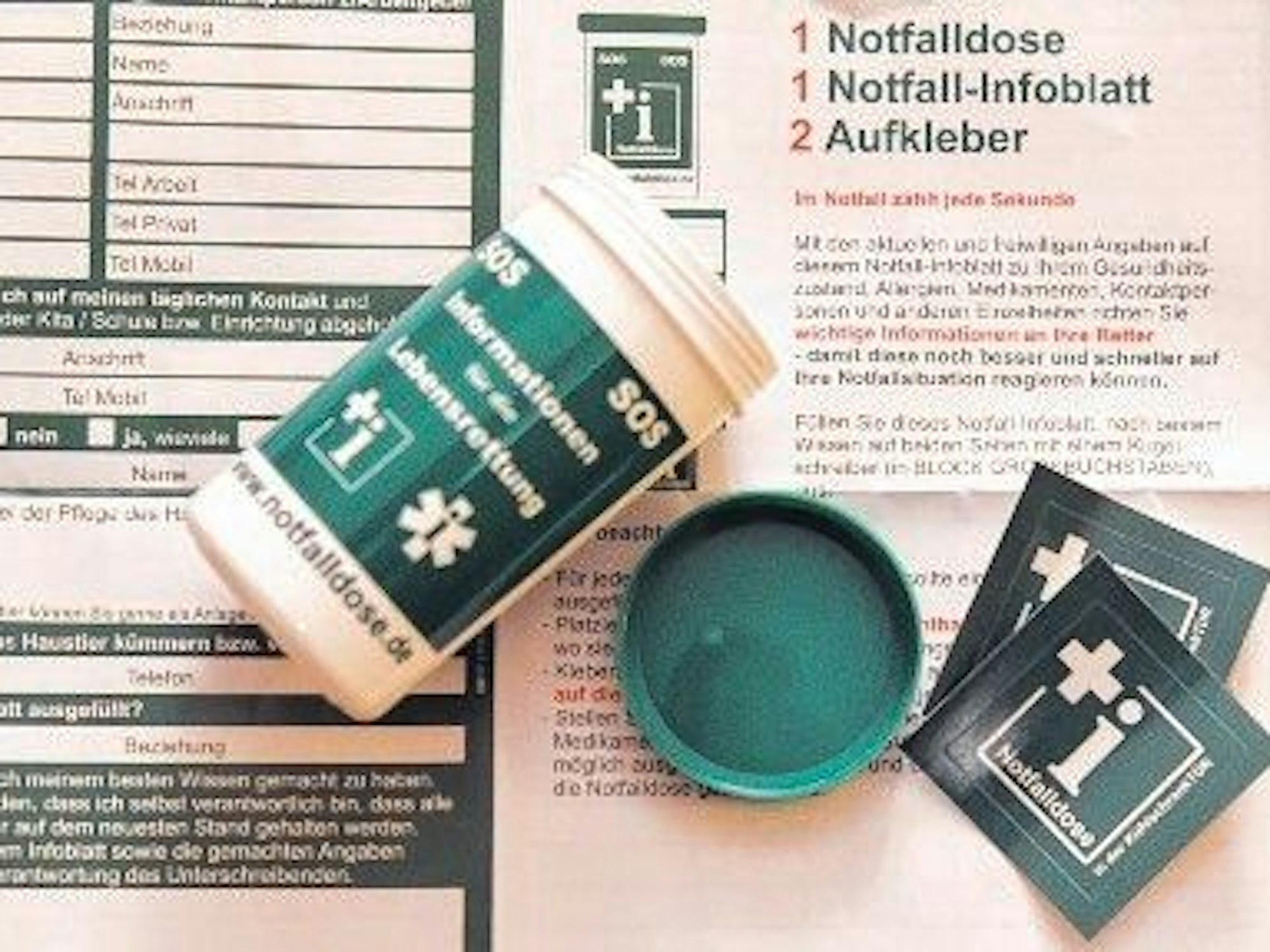 Eine Notfalldose liegt auf einem Infoblatt.