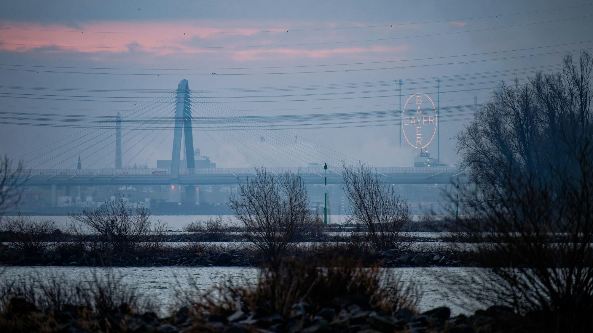 Der morgentliche Himmel leuchtet über dem Rhein orange.