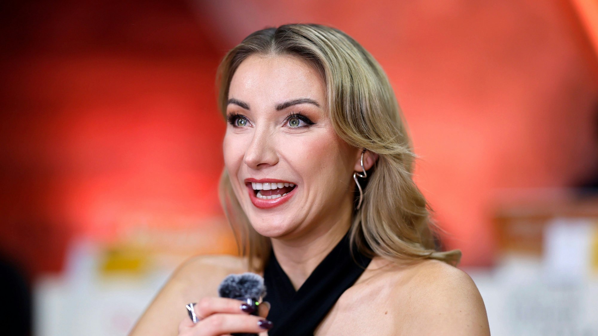 Anna-Carina Woitschack lächelt mit Mikrofon.