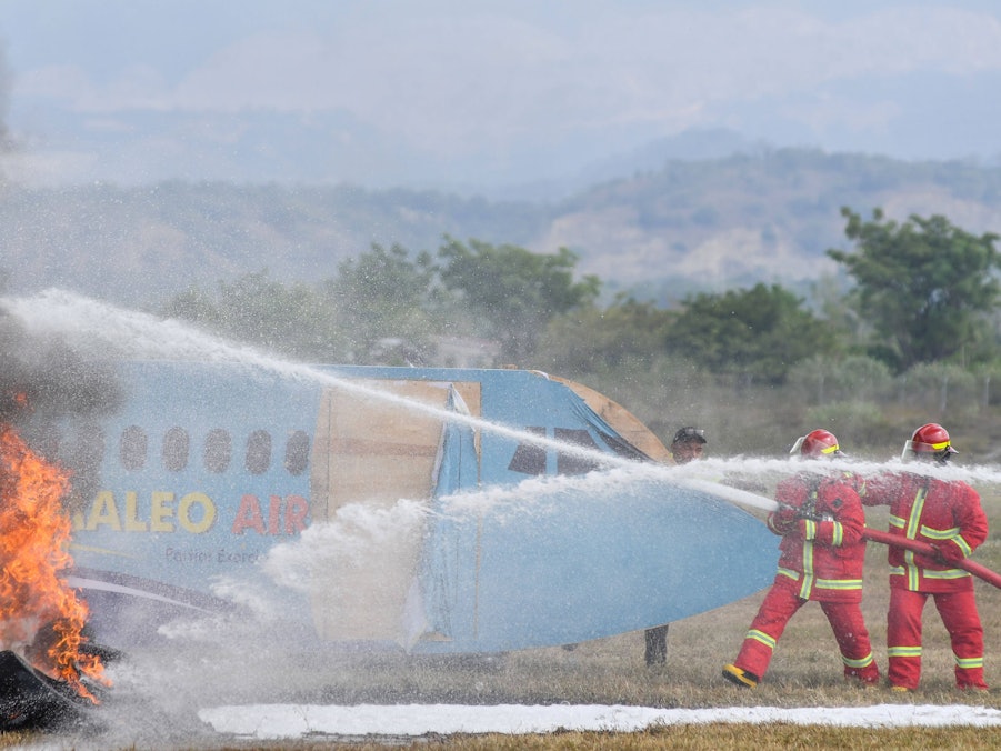 Feuerwehrleute löschen Brand an einem Flugzeug