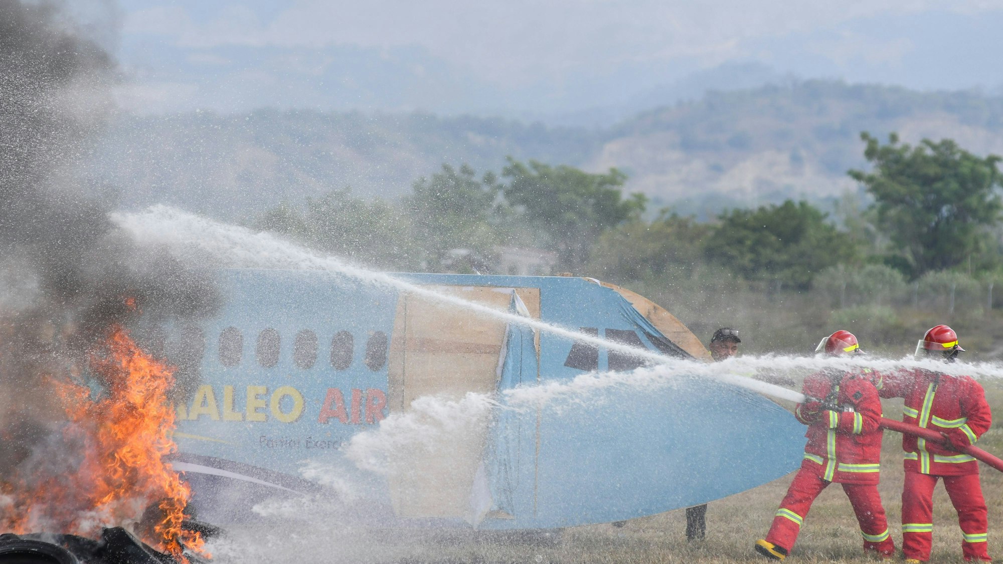 Feuerwehrleute löschen Brand an einem Flugzeug