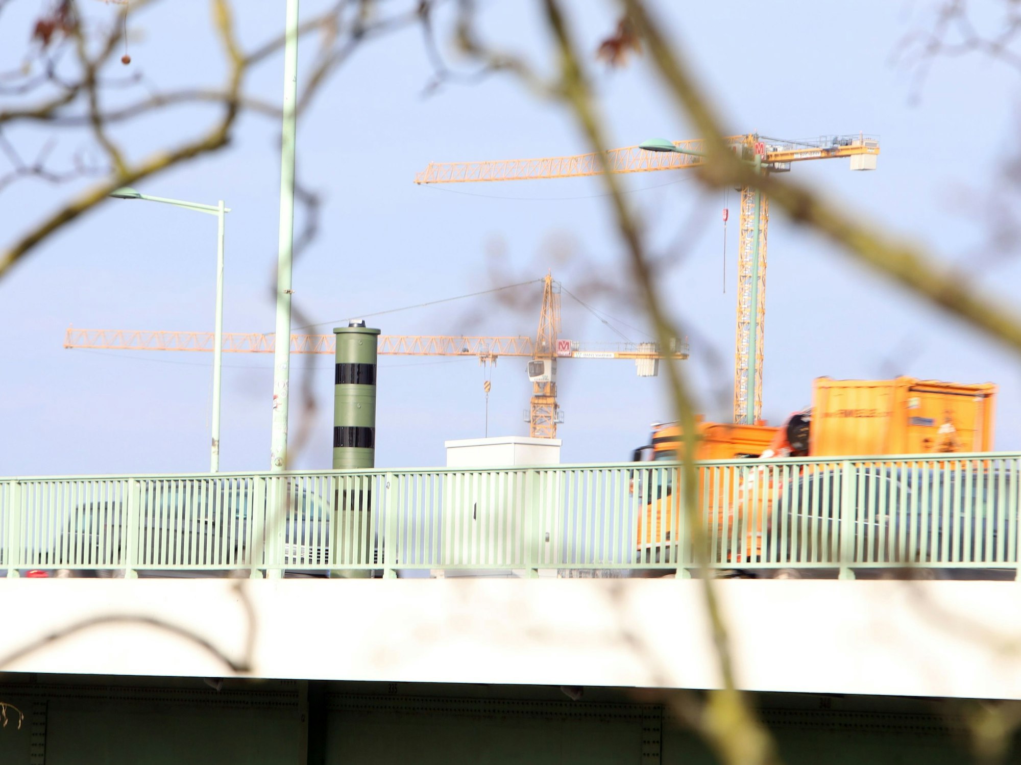 Ein Blitzer steht auf einer Brücke, ein Lkw nähert sich.