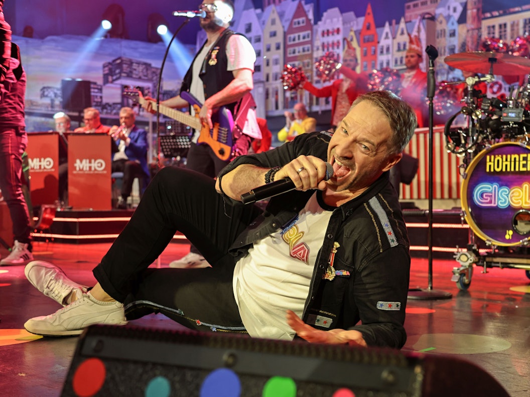 Patrick Lück von den Höhnern liegt auf der Bühne.